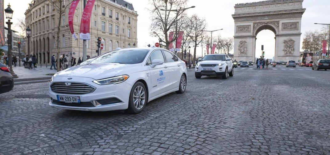 A self-driving vehicle from Mobileye’s autonomous fleet drives through the streets of Paris, with the Arc de Triomphe in the background. (Credit: Mobileye)