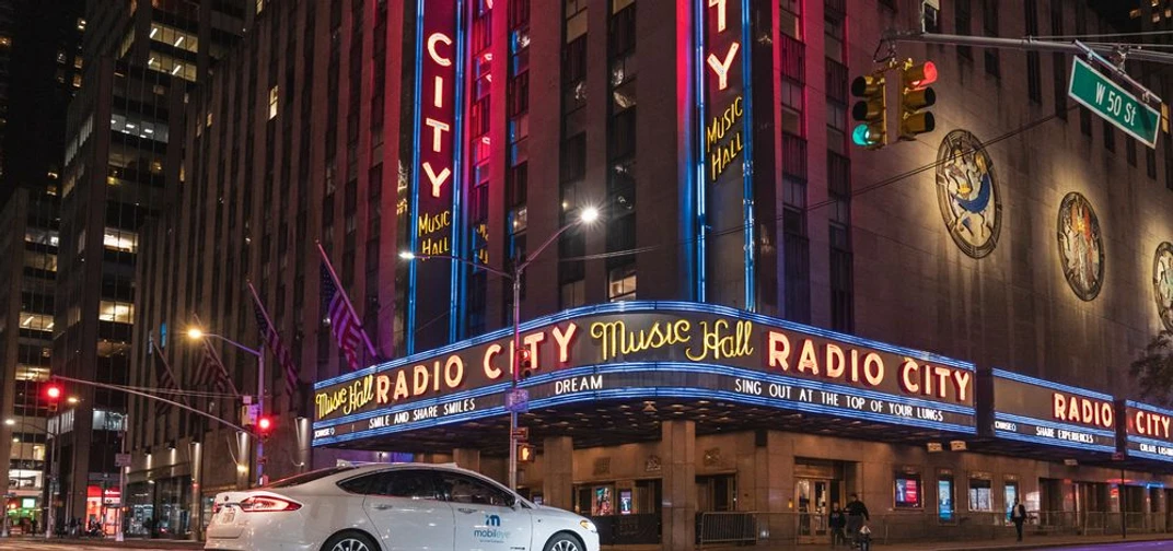 A self-driving vehicle from Mobileye’s autonomous test fleet drives by the iconic New York City Radio City Music Hall in June 2021.