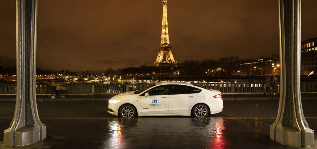 A self-driving vehicle from Mobileye’s autonomous fleet drives past the Eiffel Tower at night in Paris. (Credit: Mobileye)